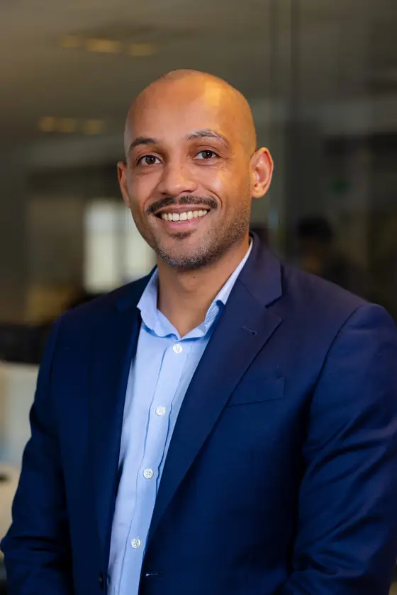 Portrait of a smiling man wearing a blue suit jacket.