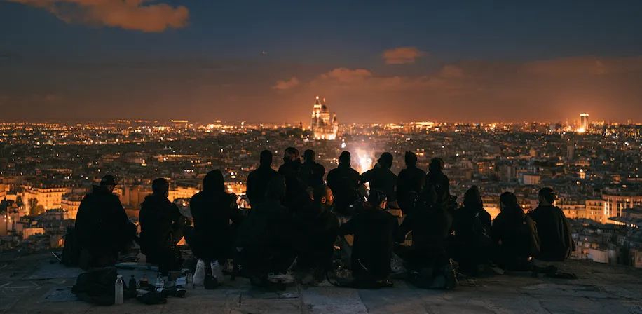 L’équipe de Samouraï Coop réunie sur un toit face à Paris et au Sacré-Cœur à la tombée de la nuit